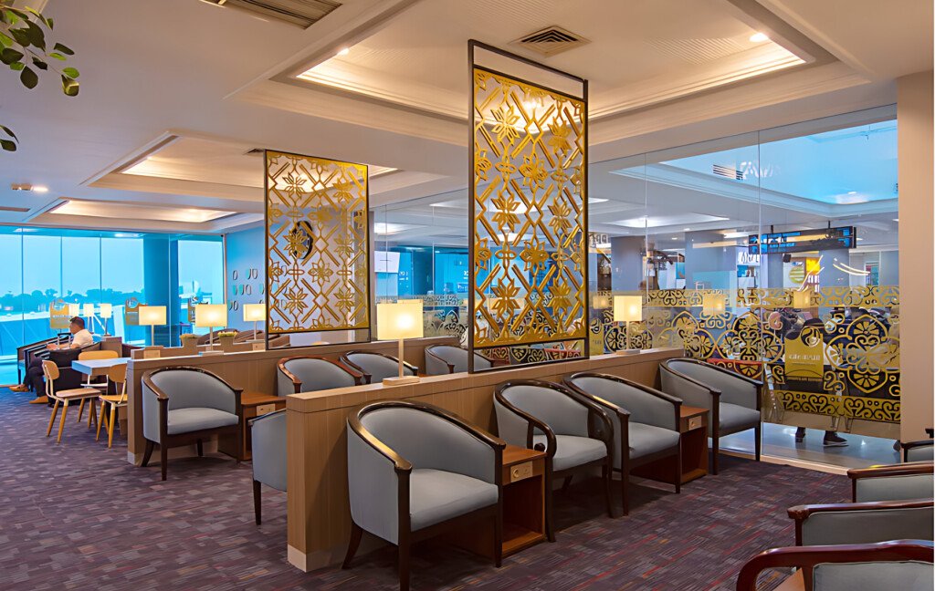 area duduk nyaman di airport dimensions blue sky premier lounge palembang dengan dekorasi motif emas dan pemandangan bandara