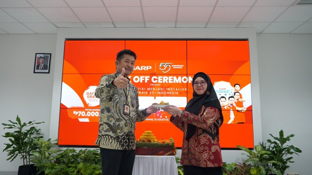 President Director PT Sharp Electronics Indonesia, Shinji Teraoka, bersama Head of Customer Satisfaction Division, Lise Tiasanty, memotong tumpeng saat peresmian program Sharp AC Installer Championship 2025.