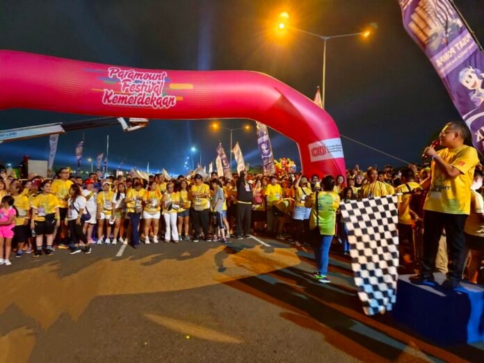 Direktur Paramount Land, Norman Daulay, meresmikan dimulainya City Night Walk dalam acara Paramount Festival Kemerdekaan 2025 di Gading Serpong, tampak peserta siap berjalan dan bendera start dikibarkan.