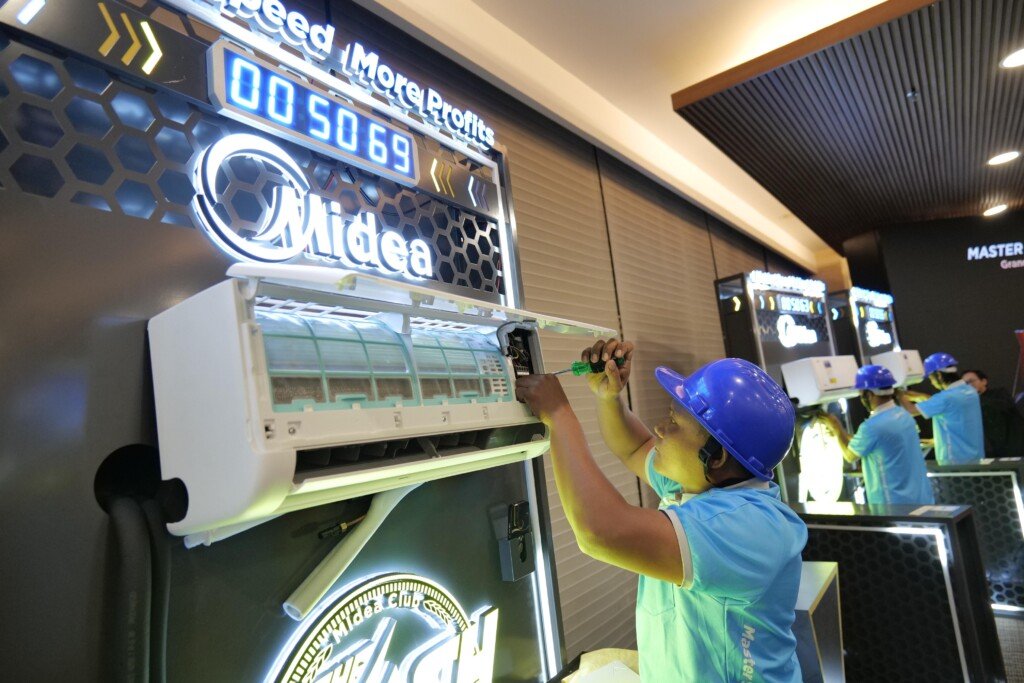Seorang teknisi AC Midea sedang melakukan instalasi dengan cepat selama kompetisi Midea Club ASEAN Flash Installation Tournament.