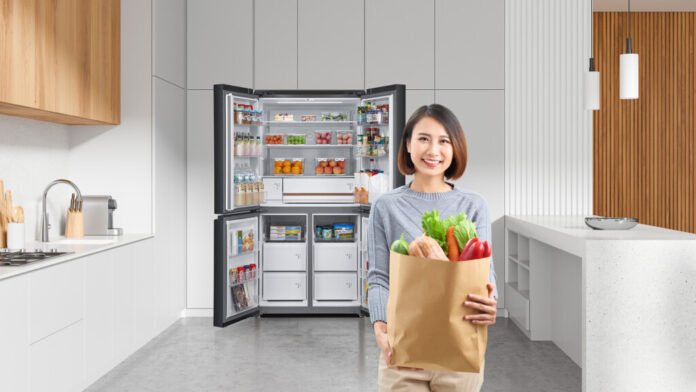 Wanita membawa belanjaan segar di dapur modern dengan kulkas Toshiba Nature Pure Series kapasitas besar 711 liter