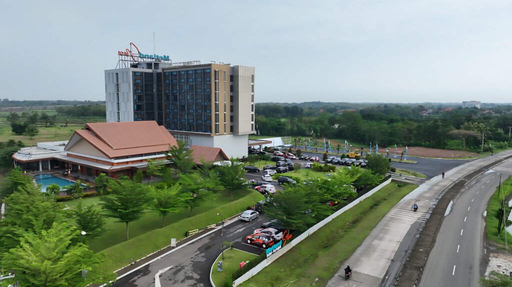 Bangunan Metland Smara Kertajati yang modern dan luas, dengan area parkir dan ballroom tradisional di depannya, berlokasi di dekat infrastruktur jalan raya.