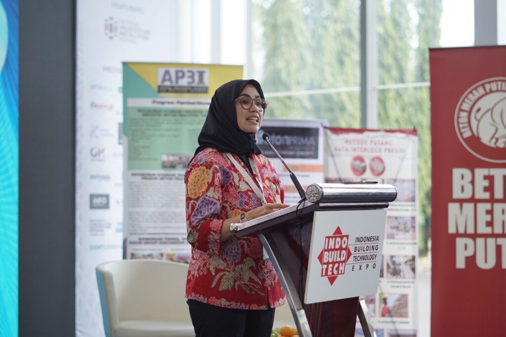 Ir. Elvi Fadilah Ketua Umum AP3I menyampaikan sambutan di seminar konstruksi berkelanjutan dalam rangkaian IndoBuildTech 2025 bersama Semen Merah Putih sosialisasi semen hijau dan beton modular.