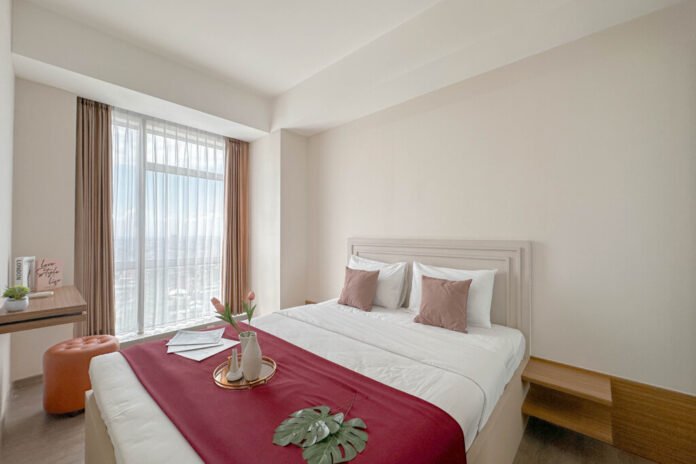 Interior kamar apartemen di Grand Sungkono Lagoon dengan desain minimalis modern, bagian dari kerja sama Travelio Grand Sungkono Lagoon untuk pengelolaan properti.