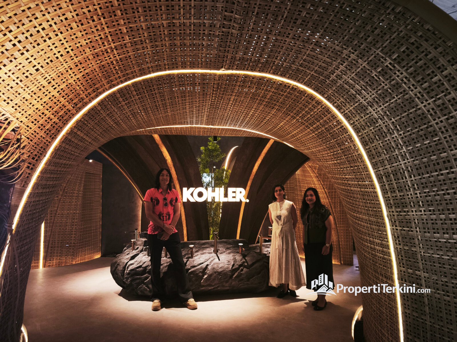 Maria Veronica Simanjuntak, Shreya Malik, dan Charlie Hearn di booth Kohler ARCH:ID 2026 dengan desain rotan dan bambu yang mencerminkan konsep kamar mandi Kohler berbasis wellness