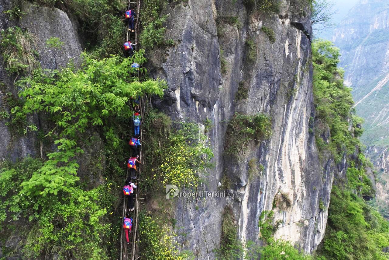 Anak-anak sekolah memanjat jalur tebing curam dengan tangga dan rantai besi di Nizhuhe Yunnan China sebelum hadirnya Lift Tebing Yunnan Sky School Bus.