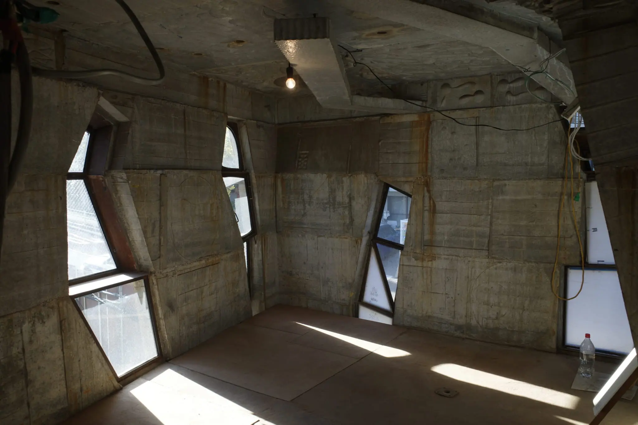 Interior Arimasuton Building Tokyo dengan dinding beton eksperimental dan jendela geometris tidak beraturan