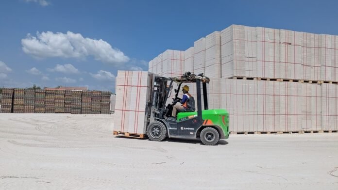 forklift-listrik-pabrik-bata-ringan-bles Operator mengemudikan forklift listrik saat memindahkan tumpukan bata ringan BLES di area fasilitas produksi