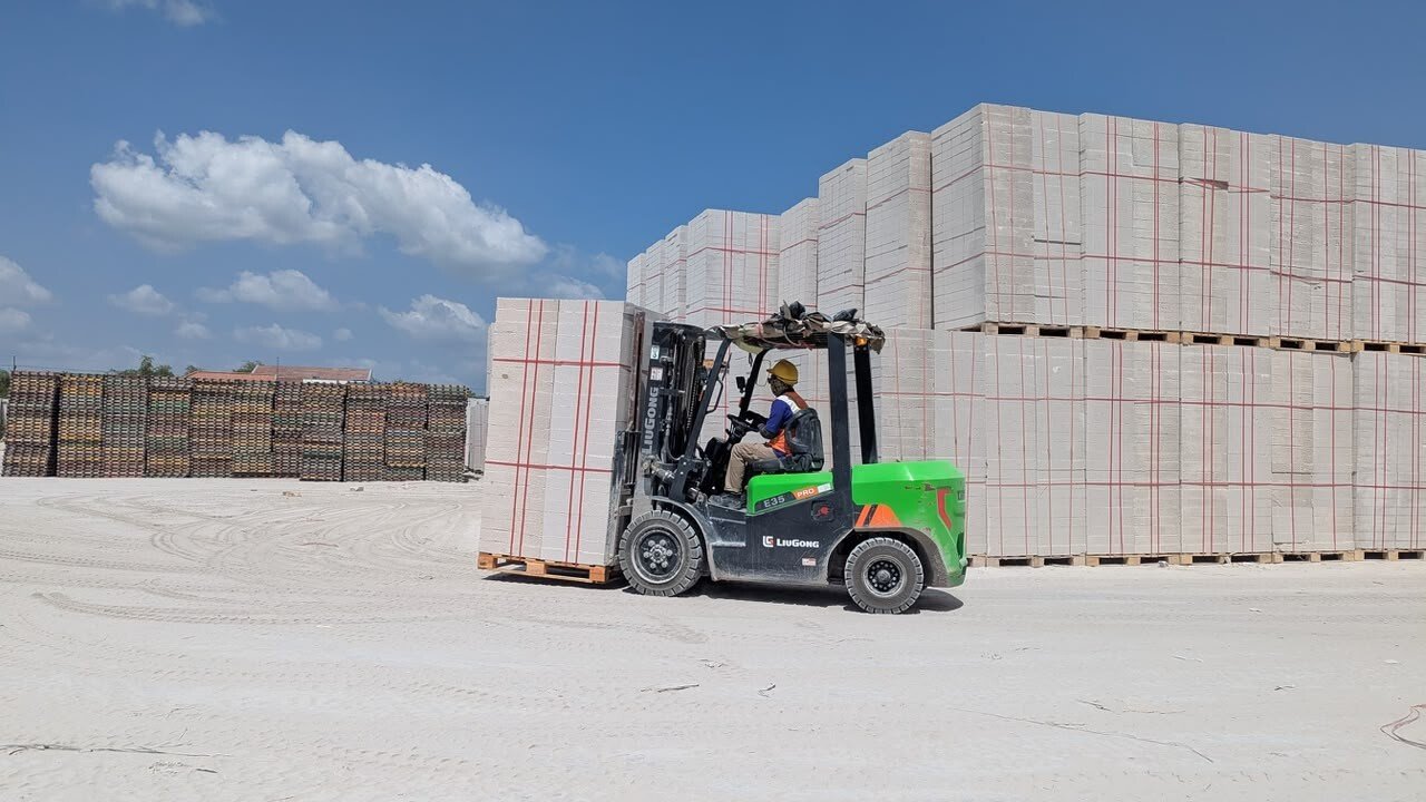 Operator mengemudikan forklift listrik saat memindahkan tumpukan bata ringan BLES di area fasilitas produksi